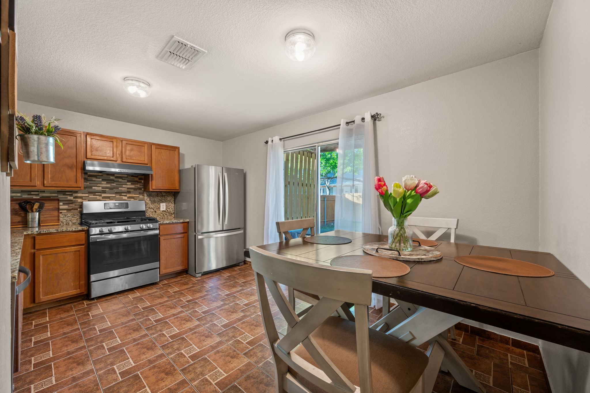 14206 Varrelman Street Austin, TX 78725 - Photo 8 of 27 a kitchen with a table and refrigerator