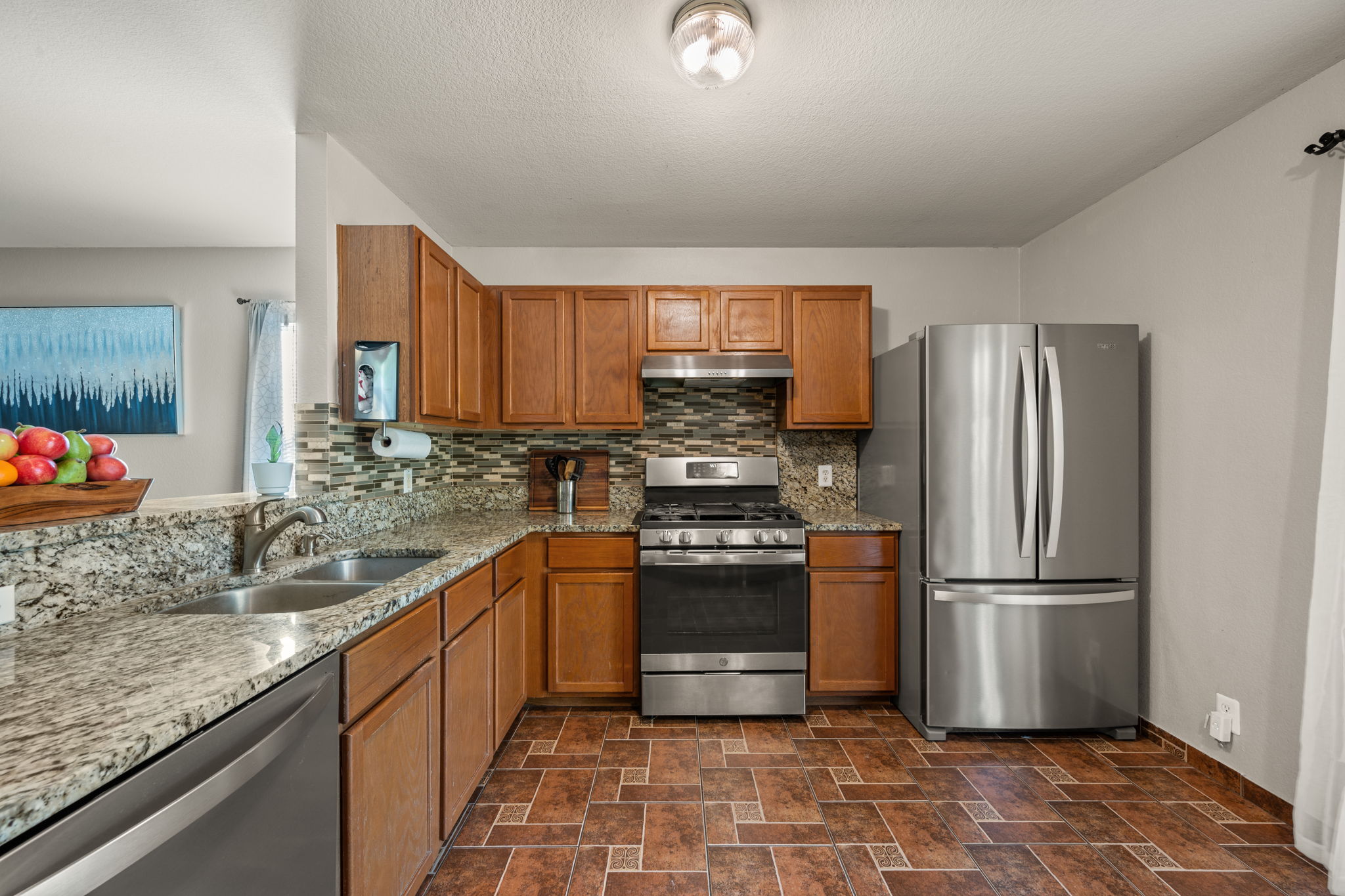 14206 Varrelman Street Austin, TX 78725 - Photo 10 of 27 a kitchen with stainless steel appliances granite countertop a refrigerator sink and stove