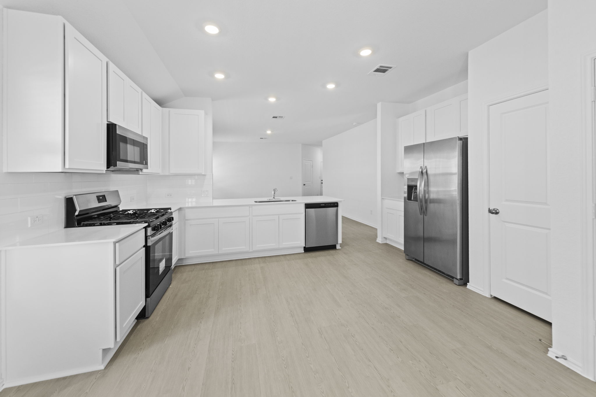 945 Soapstone Pass Maxwell, TX 78656 - Photo 11 of 19 a large kitchen with a stove a refrigerator and a sink