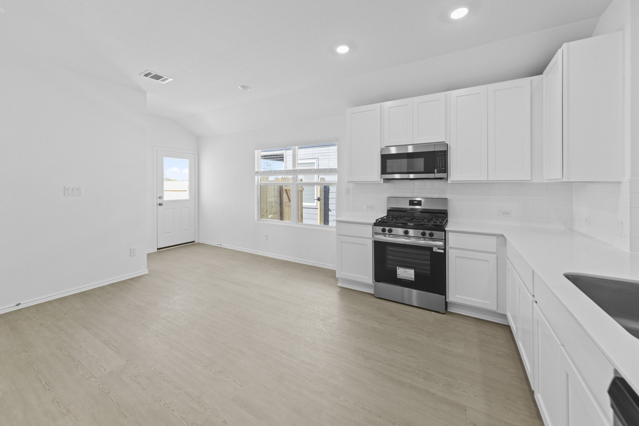 945 Soapstone Pass Maxwell, TX 78656 - Photo 12 of 19 a kitchen with granite countertop a stove a sink and a microwave