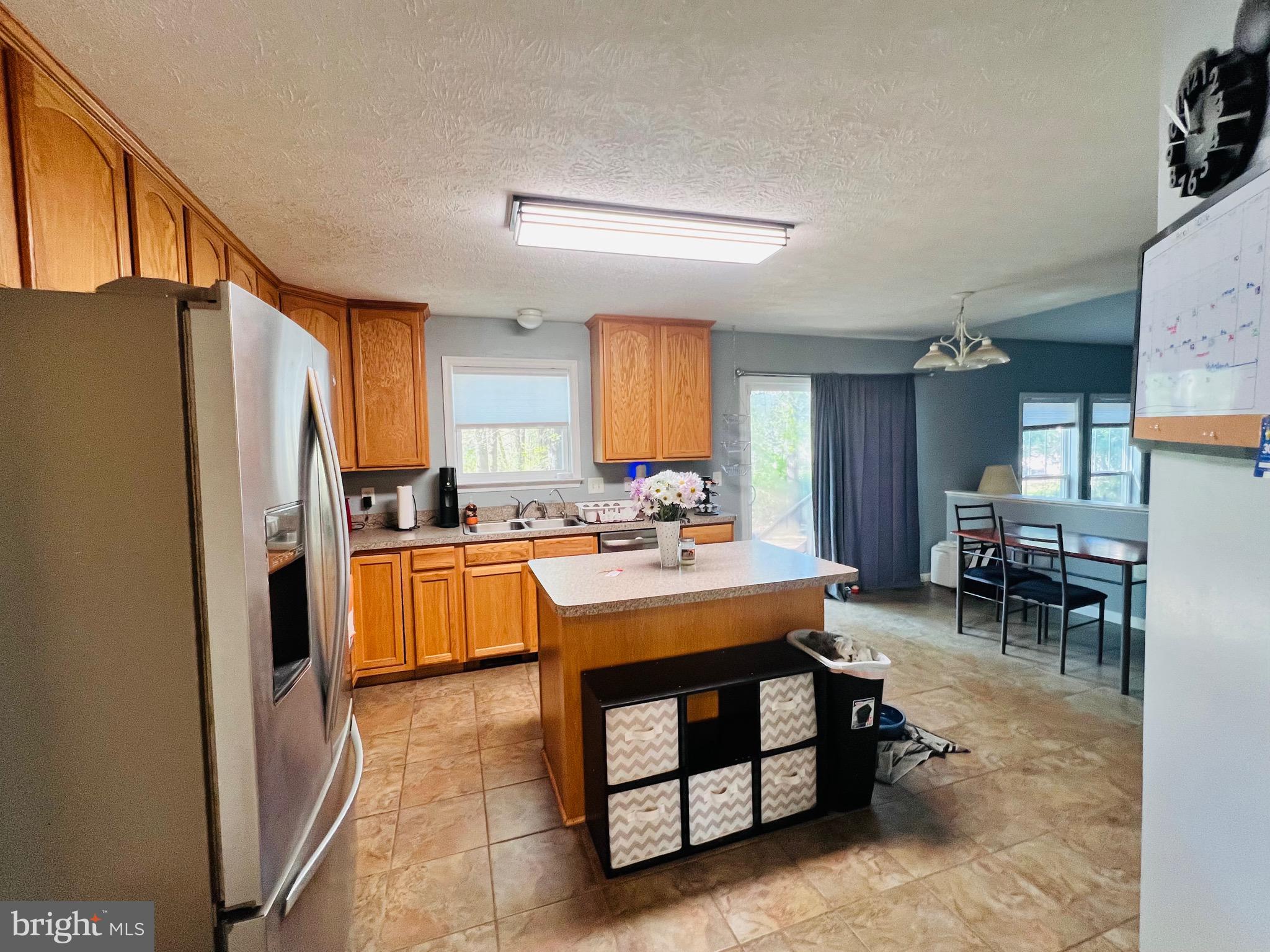 213 Forest Avenue Colonial Beach, VA 22443 - Photo 19 of 54 a kitchen with a refrigerator a table and chairs in it