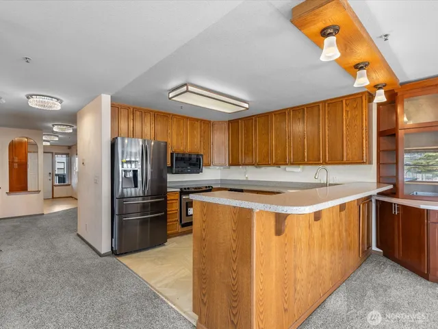 a kitchen with stainless steel appliances granite countertop a refrigerator and a sink
