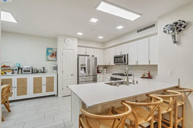 a kitchen with stainless steel appliances granite countertop a refrigerator and a stove top oven