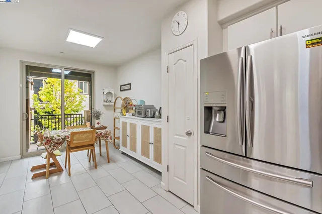 a kitchen with white cabinets and refrigerator