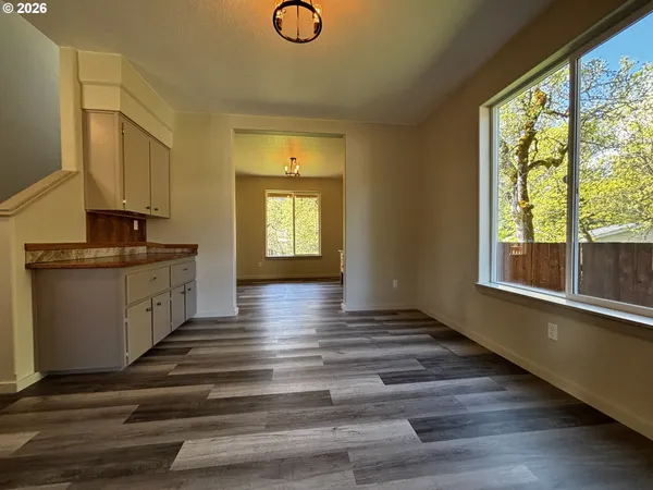 a kitchen with kitchen island granite countertop a stove a sink and white cabinets with wooden floor