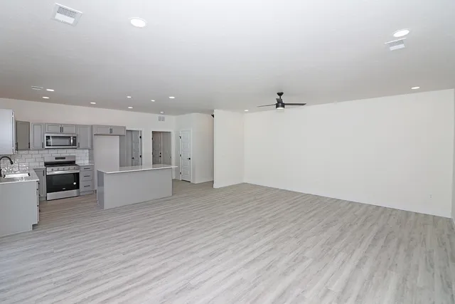 a kitchen with stainless steel appliances a refrigerator sink and stove