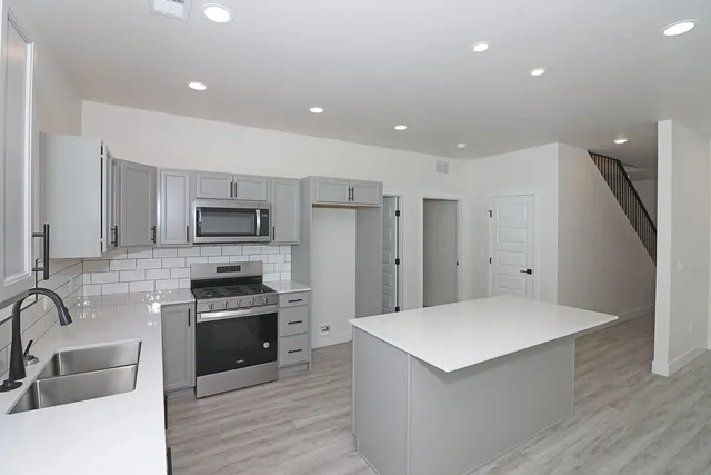 a kitchen with a refrigerator sink and cabinets