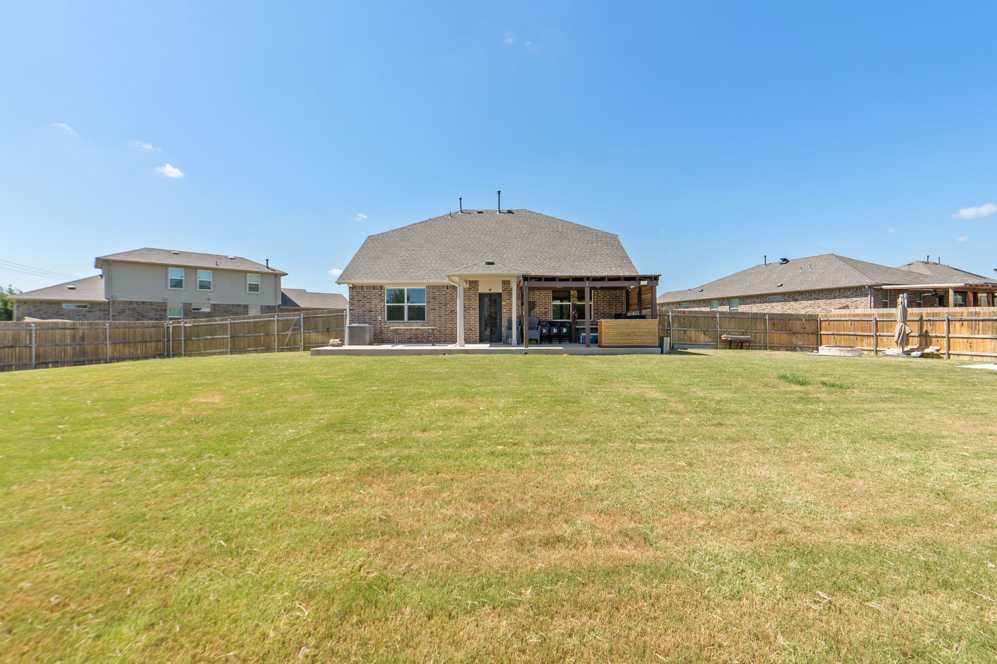 142 Brunnen Way Georgetown, TX 78626 - Photo 21 of 22 A spacious backyard with a private fence, featuring a covered patio for outdoor entertaining.