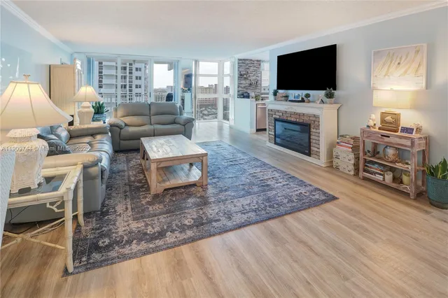 a living room with furniture a flat screen tv and a fireplace