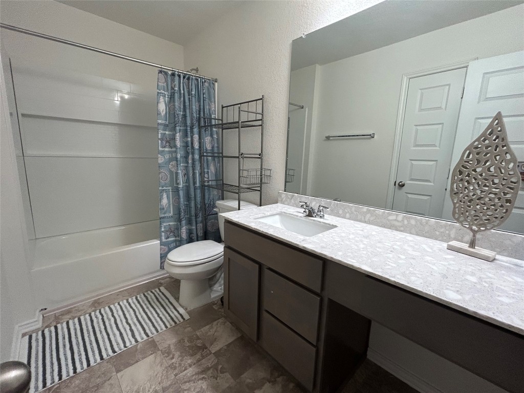 420 Lt. Rusty Jarrell, TX 76537 - Photo 13 of 17 Full bathroom featuring shower / bath combo, vanity, stone finish floors, and a textured wall