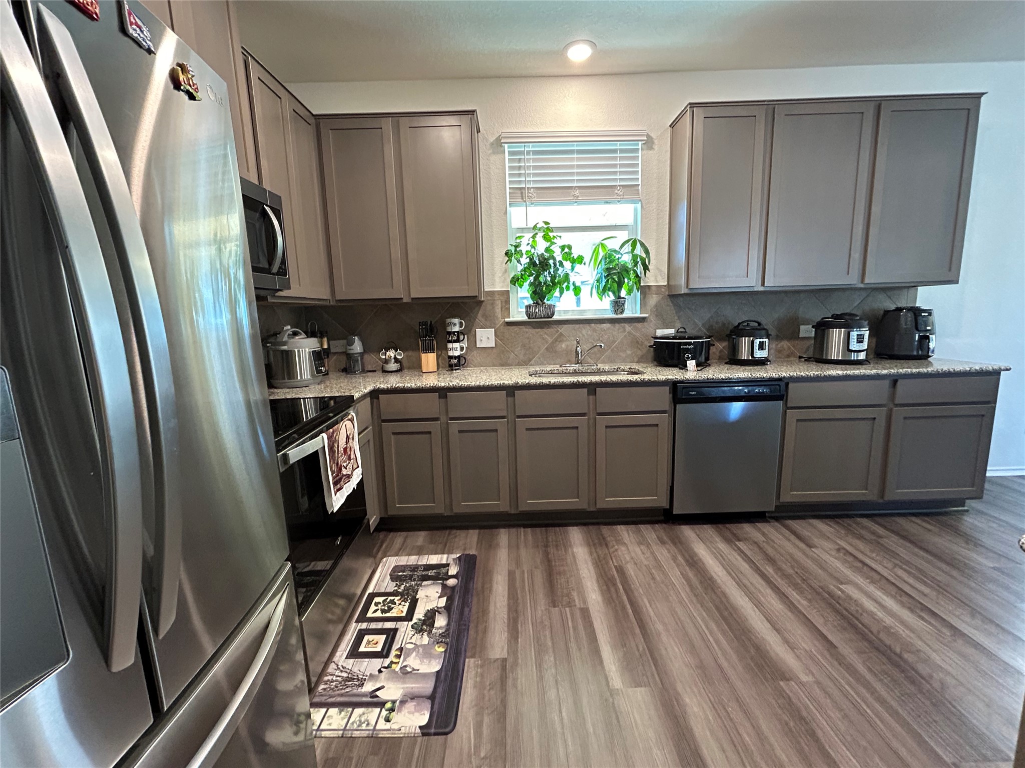 420 Lt. Rusty Jarrell, TX 76537 - Photo 7 of 17 a kitchen with stainless steel appliances granite countertop a refrigerator a sink dishwasher a stove and white countertops with wooden floor