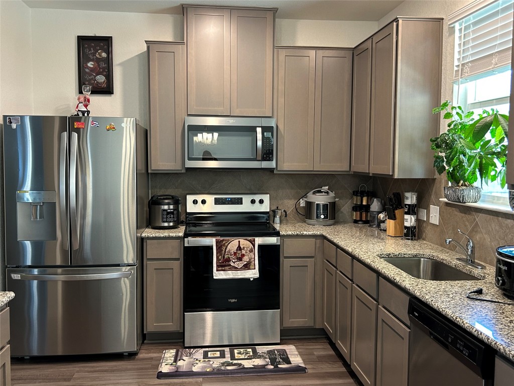 420 Lt. Rusty Jarrell, TX 76537 - Photo 8 of 17 Kitchen with appliances with stainless steel finishes, light stone countertops, gray cabinetry, and dark wood-style flooring