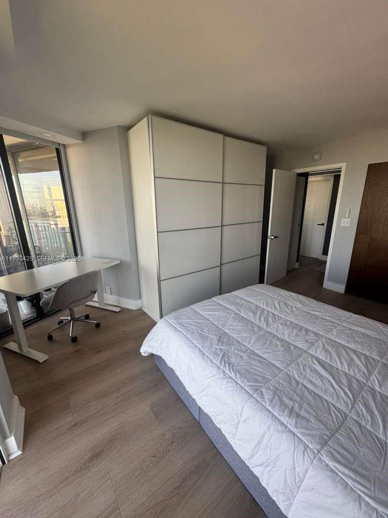 4000 Towerside Terrace, Unit 1901 Miami, FL 33138 - Photo 30 of 33 a bedroom with a bed and wooden floor