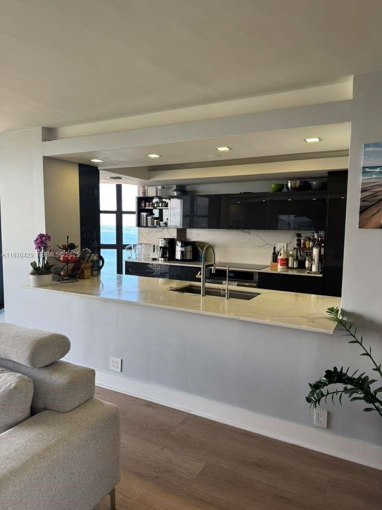 4000 Towerside Terrace, Unit 1901 Miami, FL 33138 - Photo 10 of 33 a living room with stainless steel appliances kitchen island granite countertop a couch and a counter space