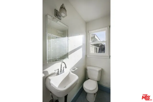a view of a room that has wooden floor and a window