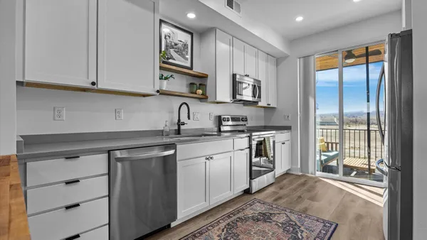 a kitchen with stainless steel appliances granite countertop a stove a sink and a refrigerator