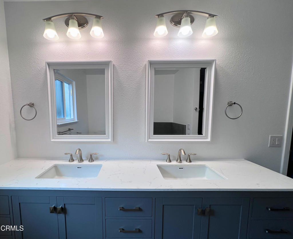 10945 Kings Road Ventura, CA 93004 - Photo 11 of 19 a bathroom with double vanity sinks and a mirror