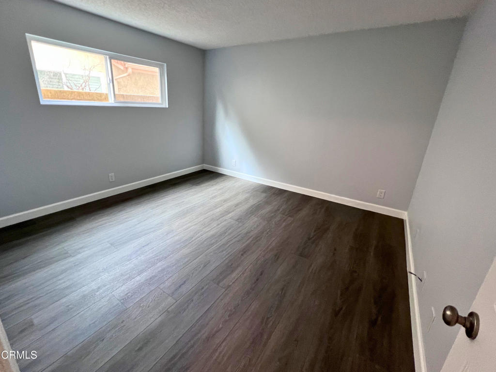 10945 Kings Road Ventura, CA 93004 - Photo 15 of 19 a view of an empty room with wooden floor and a window