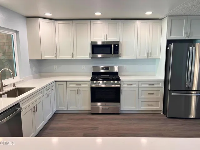 a view of a kitchen with wooden cabinet