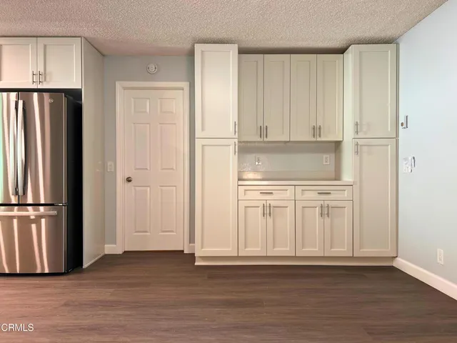 a view of kitchen with stainless steel appliances cabinets and wooden floor