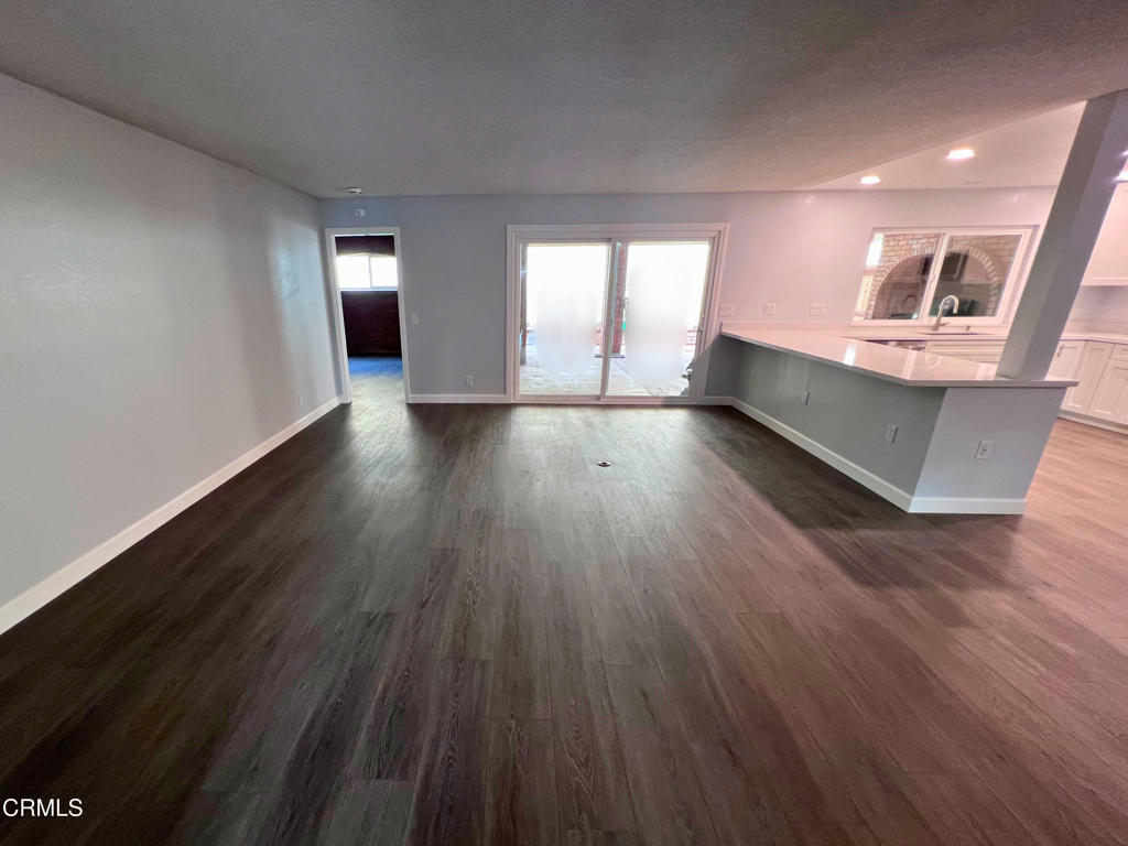 10945 Kings Road Ventura, CA 93004 - Photo 10 of 19 a view of an empty room with wooden floor and a window