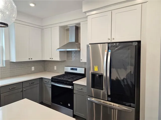 a kitchen with a refrigerator and white cabinets