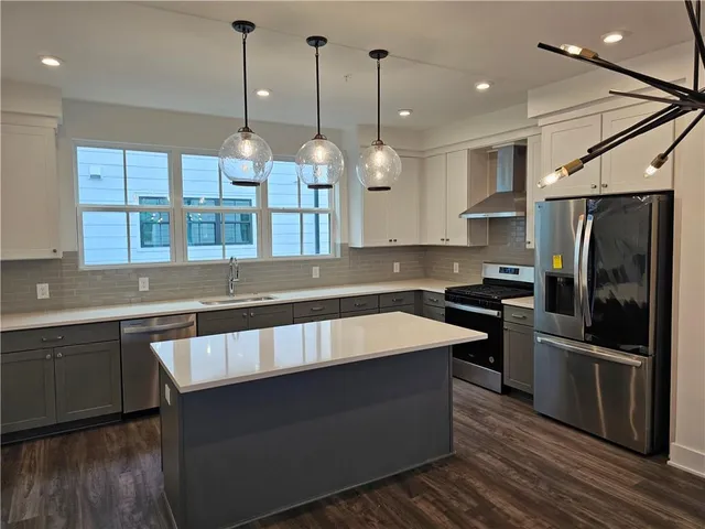 a kitchen with stainless steel appliances granite countertop a sink a stove and a refrigerator