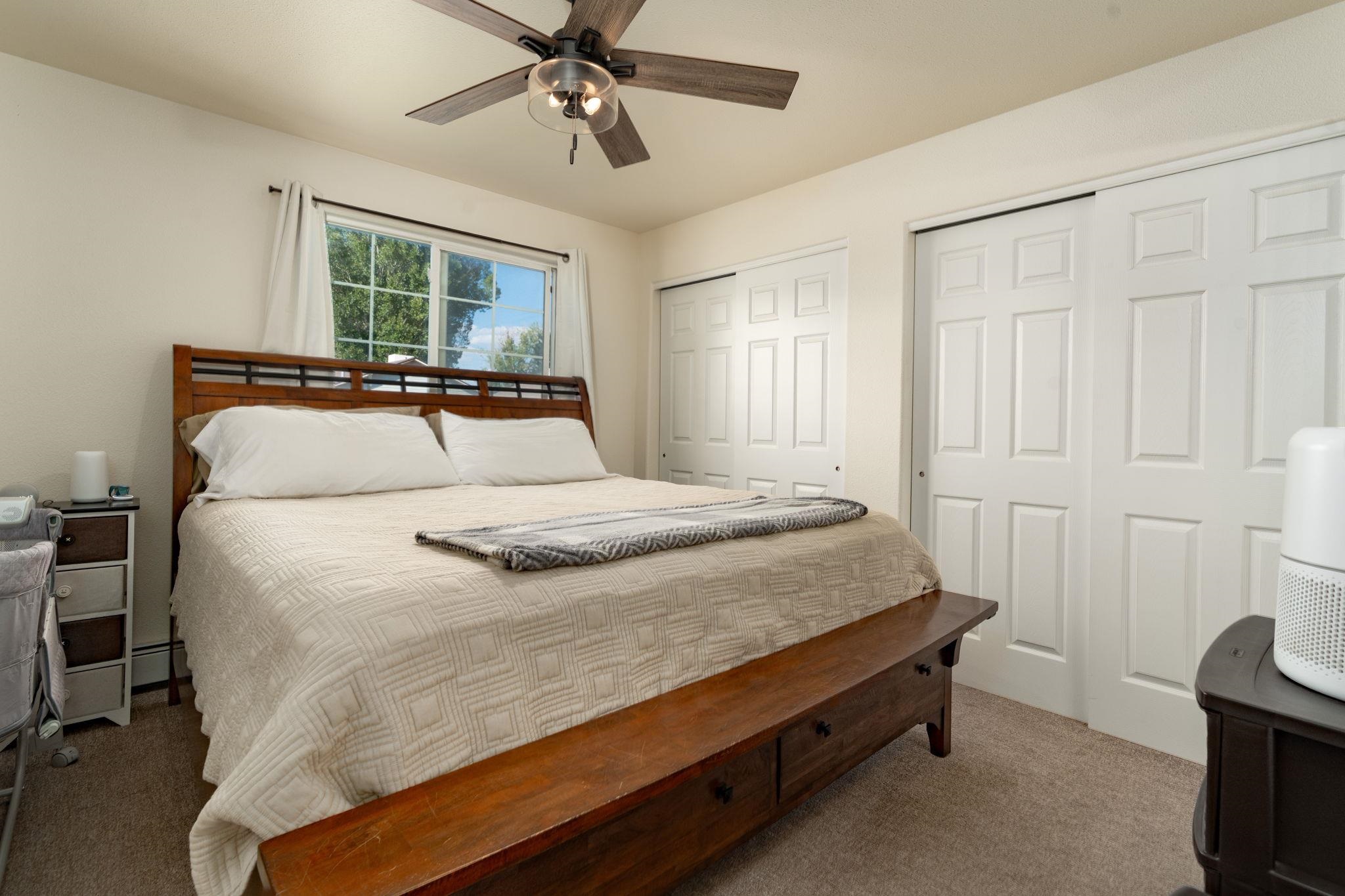 1300 Powell Street Fruita, CO 81521 - Photo 15 of 25 a bedroom with a bed and a chandelier