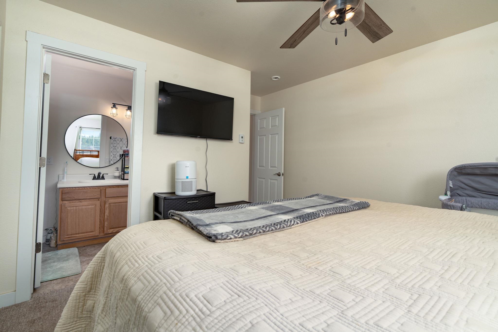1300 Powell Street Fruita, CO 81521 - Photo 16 of 25 a bedroom with a large bed and a flat screen tv