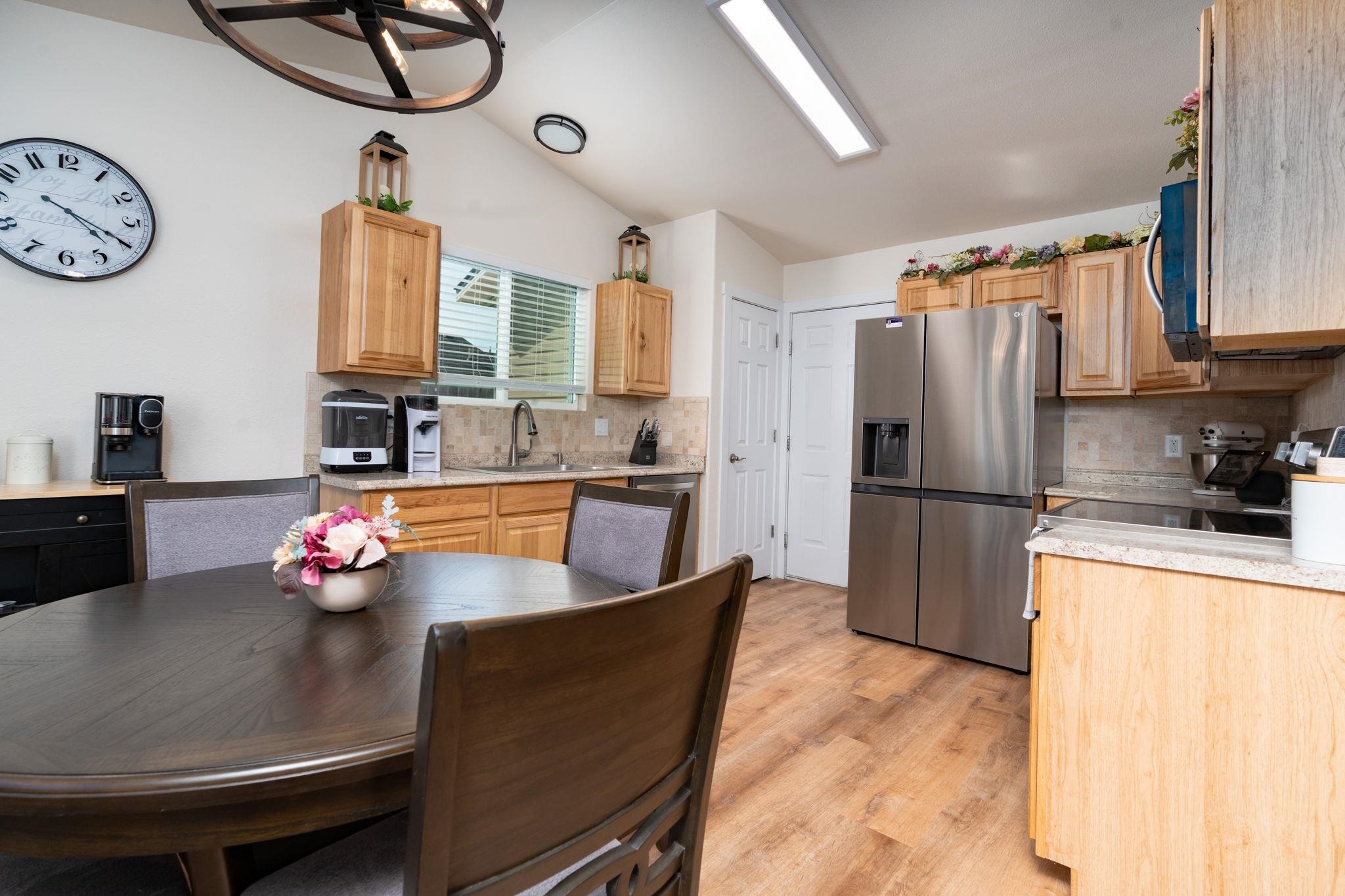 1300 Powell Street Fruita, CO 81521 - Photo 20 of 25 a kitchen with stainless steel appliances granite countertop a sink wooden cabinets and a refrigerator