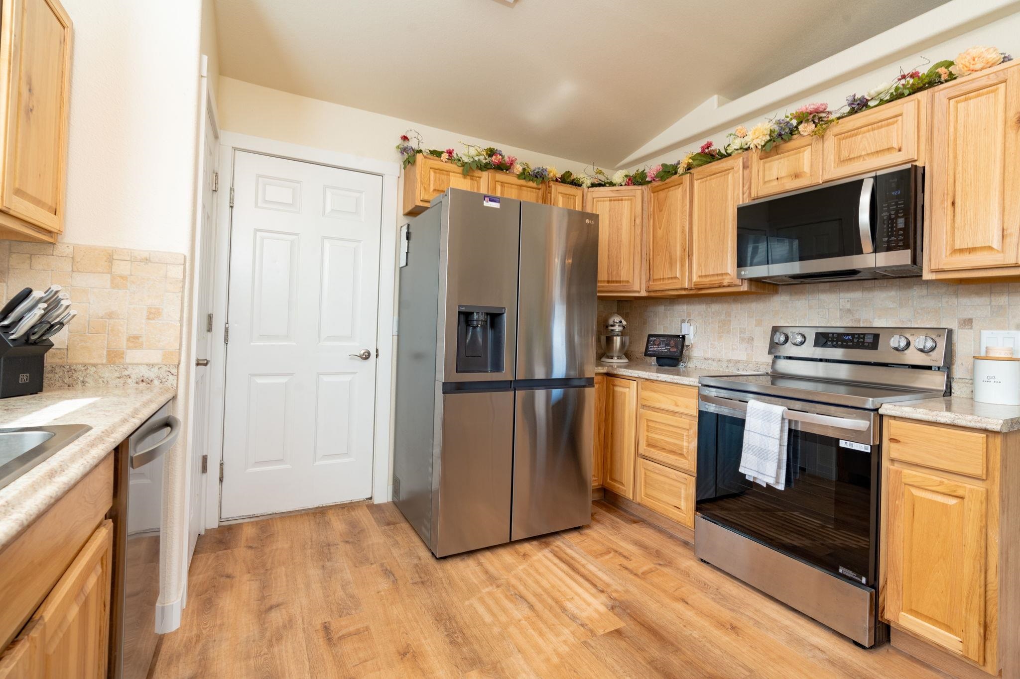 1300 Powell Street Fruita, CO 81521 - Photo 22 of 25 a kitchen with stainless steel appliances a refrigerator stove and microwave