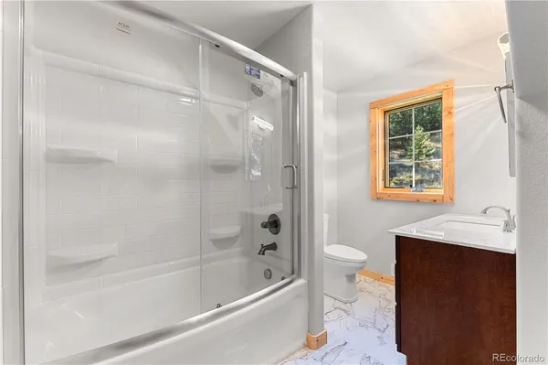 a bath room with a toilet a bath tub and a shower