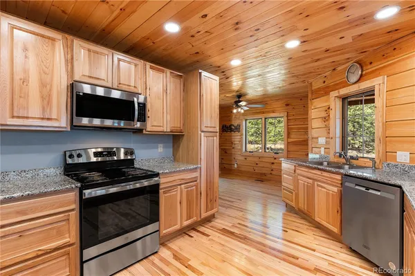 a kitchen with stainless steel appliances granite countertop a refrigerator a stove top oven a sink and dishwasher