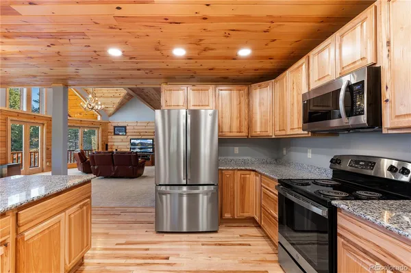 a kitchen with granite countertop a sink a counter space and stainless steel appliances