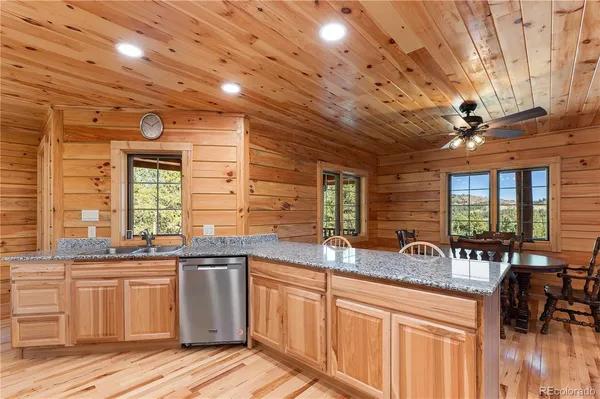a kitchen with stainless steel appliances granite countertop a stove refrigerator a sink dishwasher and microwave with wooden floor