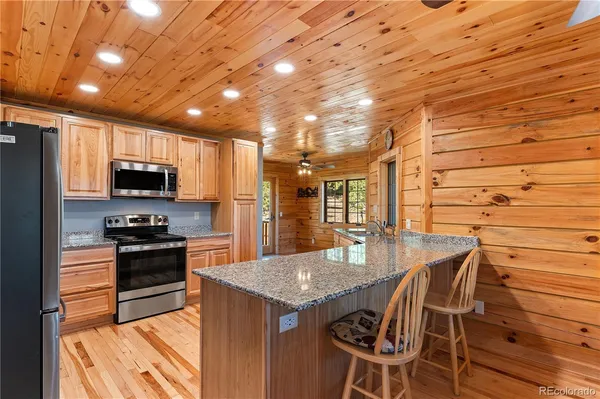 a kitchen with granite countertop stainless steel appliances and wooden cabinets
