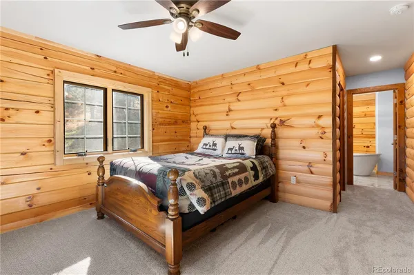 a bed sitting in a spacious bedroom next to a window