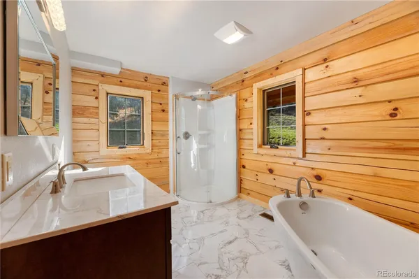 a bathroom with a tub sink and mirror