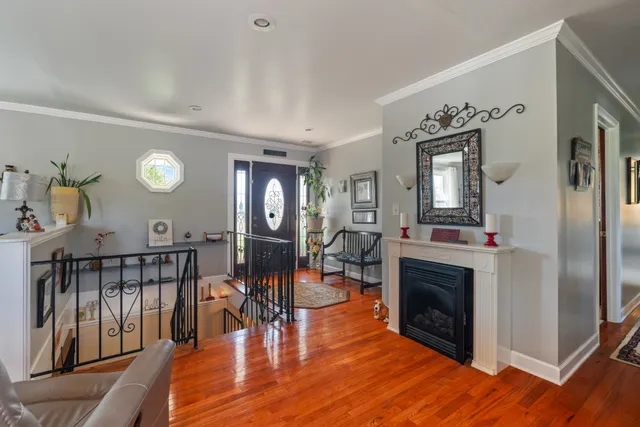 a living room with furniture a fireplace and a large mirror with wooden floor