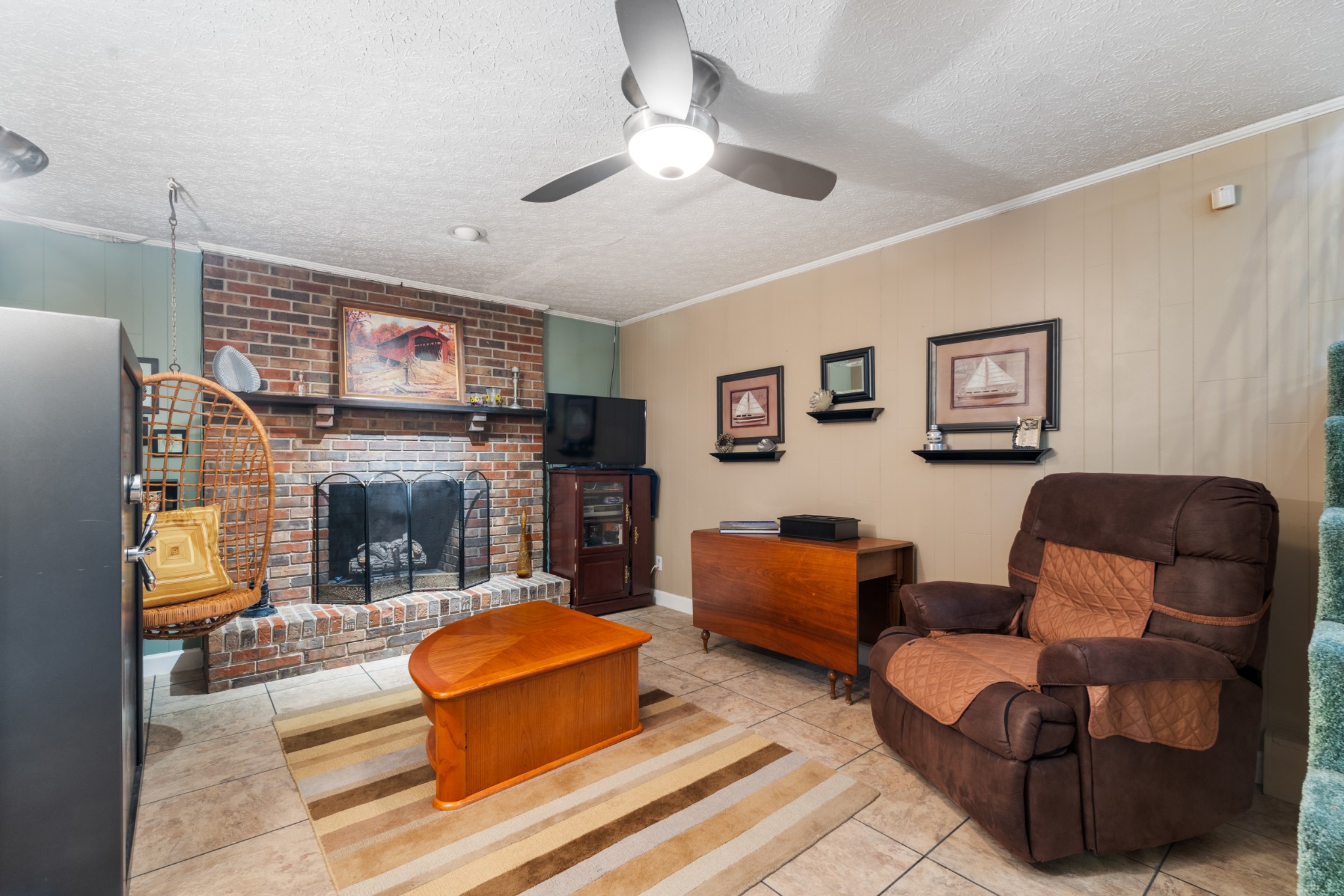 10779 North Tidwell Road Bon Aqua, TN 37025 - Photo 26 of 44 a living room with furniture a fireplace and a flat screen tv
