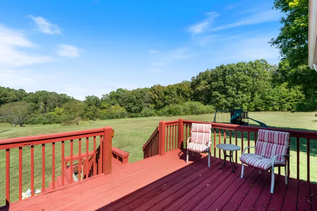 a view of a deck with chairs and wooden floor