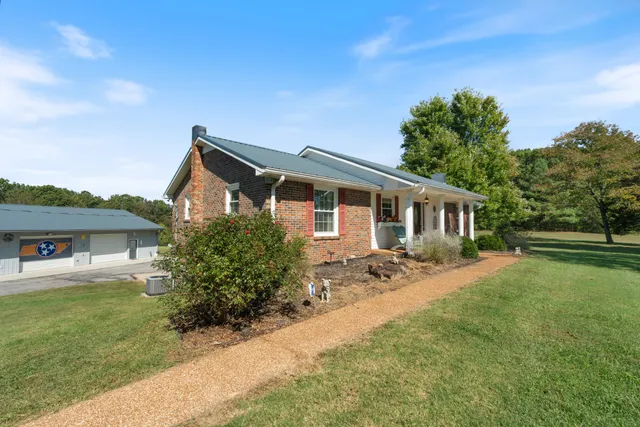 a front view of house with yard and trees in the background