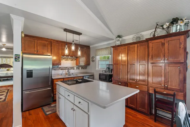 a kitchen with kitchen island granite countertop a sink appliances and cabinets