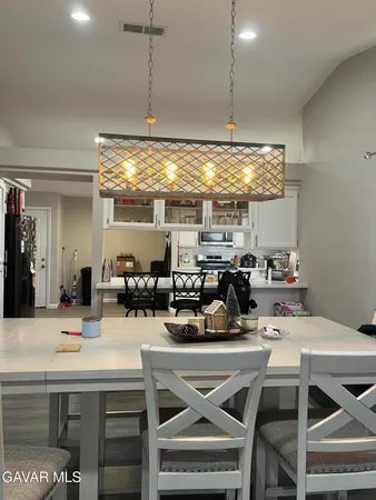 a kitchen with a dining table chairs and white cabinets