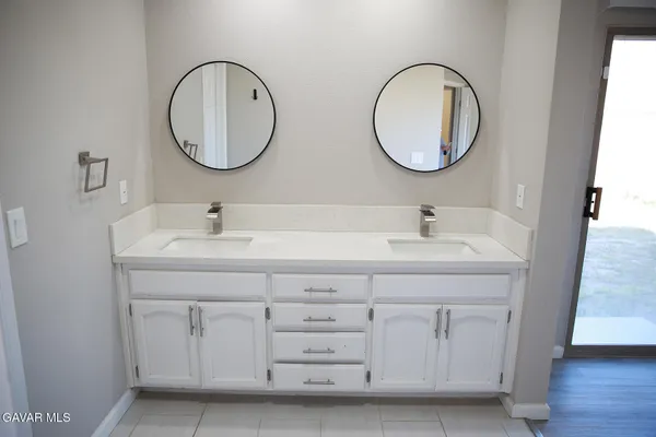 a bathroom with a double vanity sink and a mirror