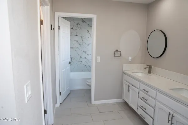 a spacious bathroom with a double vanity sink a toilet and a shower