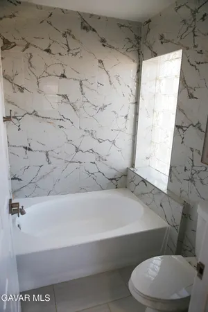 a bathroom with a white toilet and a bathtub