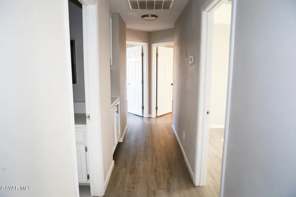 a view of a hallway with wooden floor and staircase