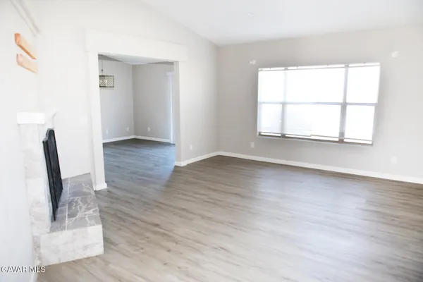 an empty room with wooden floor and a window