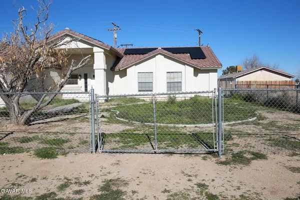 a view of a large house with a yard and lawn chairs